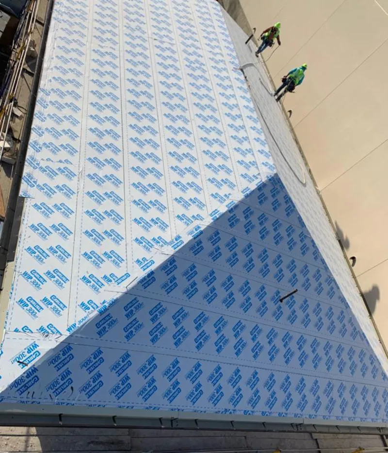 Professional roofers installing underlayment on a metal roof in North Greenbush